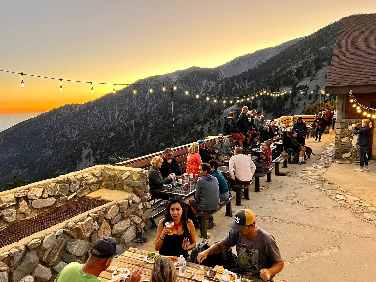 Guests on the Top of the Notch deck at sunset under string lights