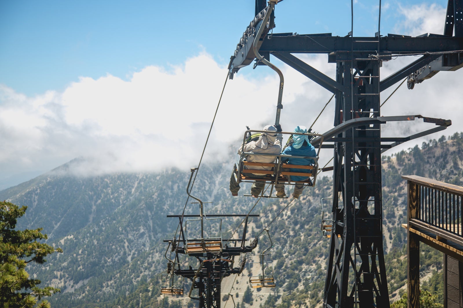 Riders on the Sugar Pine chairlift above the clouds